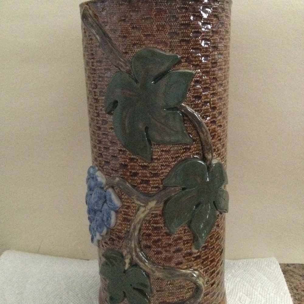 Brown vase with relief purple grapes and veins signed P E O 10.5" tall